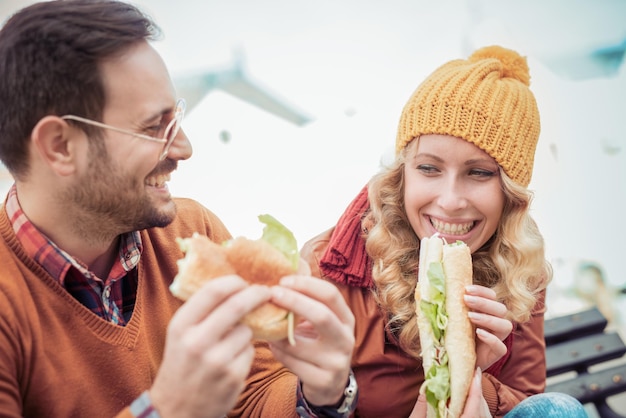 Lindo casal jovem comendo sanduíches