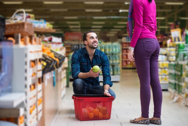 Lindo casal jovem comprando frutas e legumes no departamento de produtos de uma mercearia supermercado raso de campo