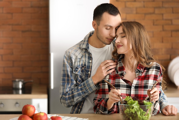 Foto lindo casal jovem cozinhando juntos na cozinha