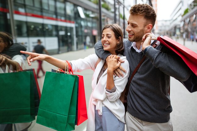 Lindo casal jovem curtindo nas compras, se divertindo juntos. consumismo, amor, namoro, conceito de estilo de vida