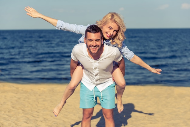 Lindo casal jovem está olhando para a câmera e sorrindo.