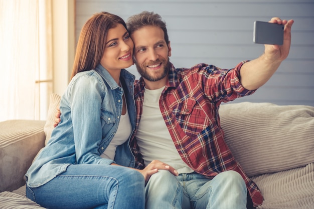 Lindo casal jovem feliz está fazendo selfie.