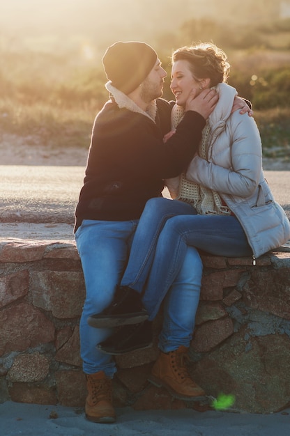 Foto lindo casal jovem na praia de inverno