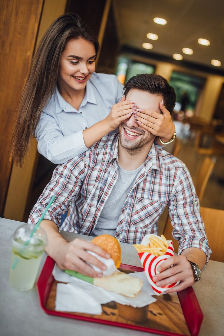 Foto lindo casal jovem no restaurante moderno fast-food se divertindo