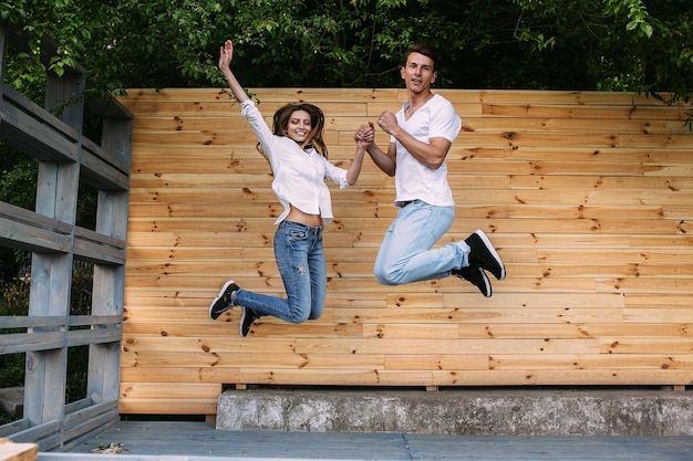 Lindo casal jovem posando em um fundo de uma parede de madeira para a câmera