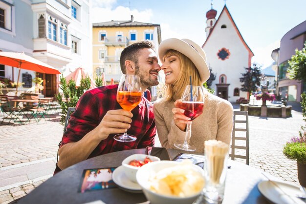 Lindo casal jovem sentado em um bar restaurante tomando uma bebida Dois amantes namorando ao ar livre