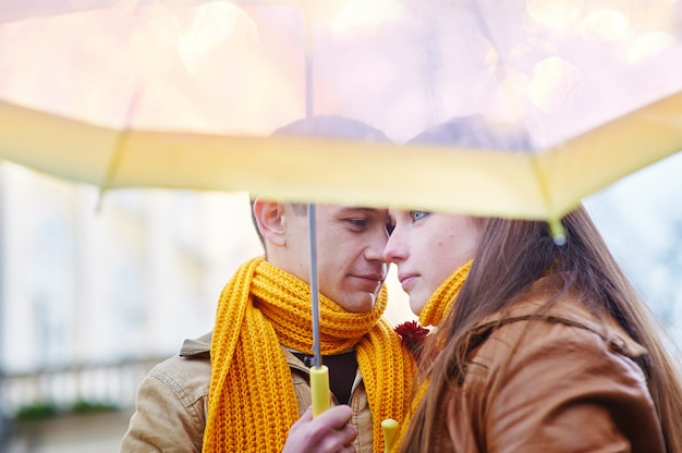 Lindo casal jovem sob um guarda-chuva na chuva