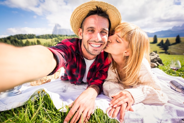 Lindo casal jovem viajando e fazendo um picínico nas Dolomitas, Itália