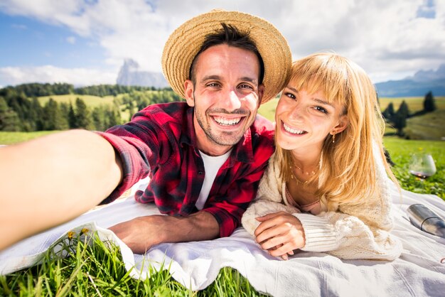 Lindo casal jovem viajando e fazendo um picínico nas Dolomitas, Itália