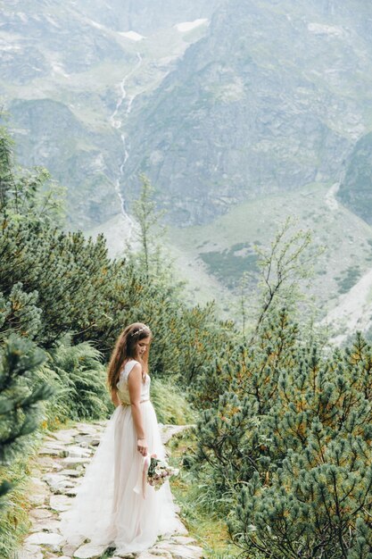 Lindo casal moderno perto de um lago nas montanhas faz fotos de casamento