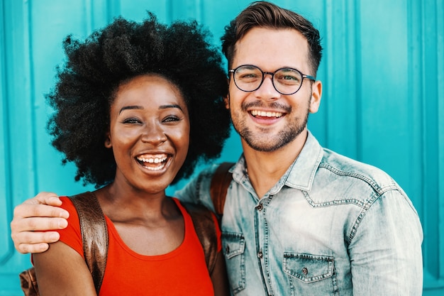 Lindo casal multicultural em pé ao ar livre, se abraçando