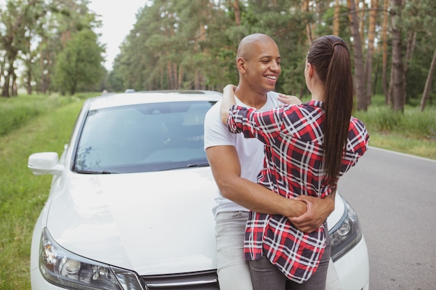 Lindo casal multirracial que gosta de viajar de carro