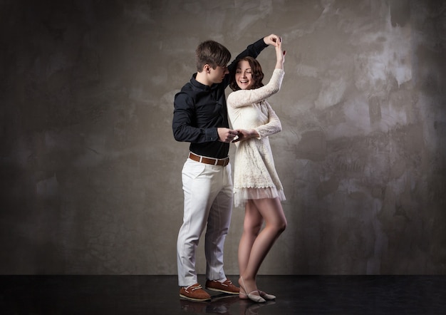 Lindo casal na dança de salão ativa em fundo escuro