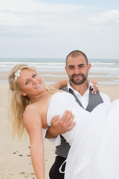 Lindo casal na praia em vestido de noiva