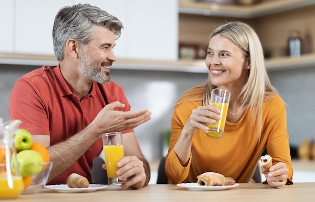 Lindo casal romântico tomando café da manhã em casa conversando