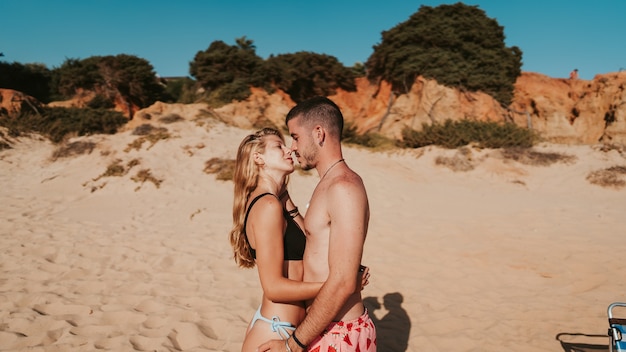 Lindo casal se abraçando em uma praia de areia