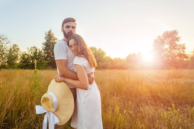 Lindo casal se abraçando no parque no pôr do sol