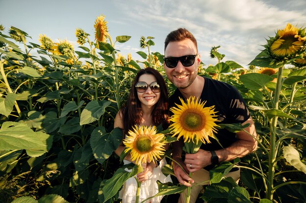 lindo casal se divertindo no campo de girassóis