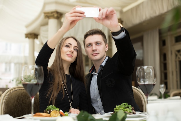 Lindo casal tirando foto de selfie em um restaurante