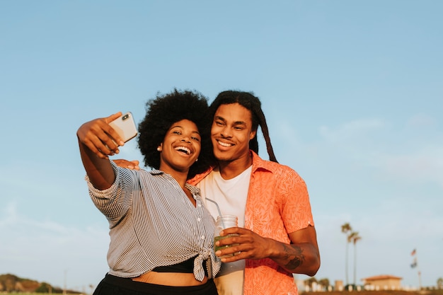 Lindo casal tomando uma selfie na praia