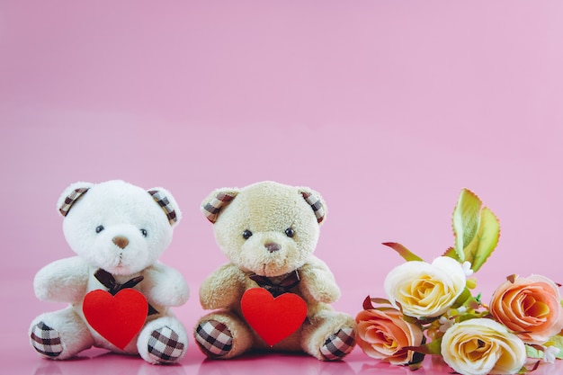 Lindo casal urso segurar o coração com fundo rosa