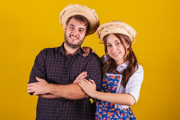 Foto lindo casal vestindo roupas típicas para a festa junina braços cruzados confiantes