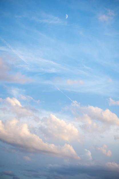 Lindo céu azul com nuvens e lua crescente à luz do dia