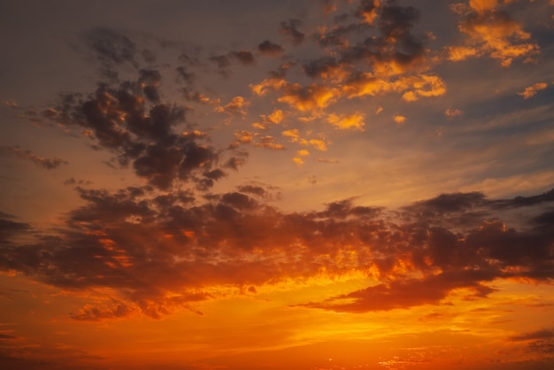 Lindo céu brilhante e colorido. Foto tirada ao pôr do sol. Fundo vermelho-laranja com belas tintas. Nascer do sol raro. Composição natural