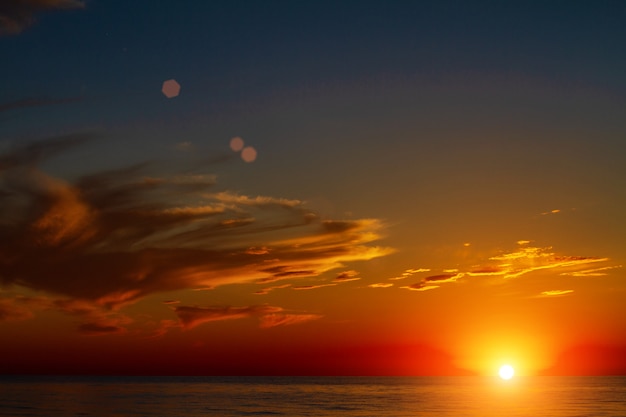 Lindo céu com nuvens ao pôr do sol sobre o mar