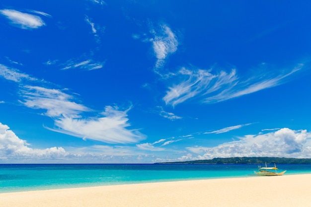 Lindo céu com nuvens sob a praia tropical Barco à vela e areia branca