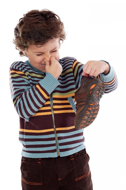 Lindo chico joven con un zapato apestoso lanzando su nariz