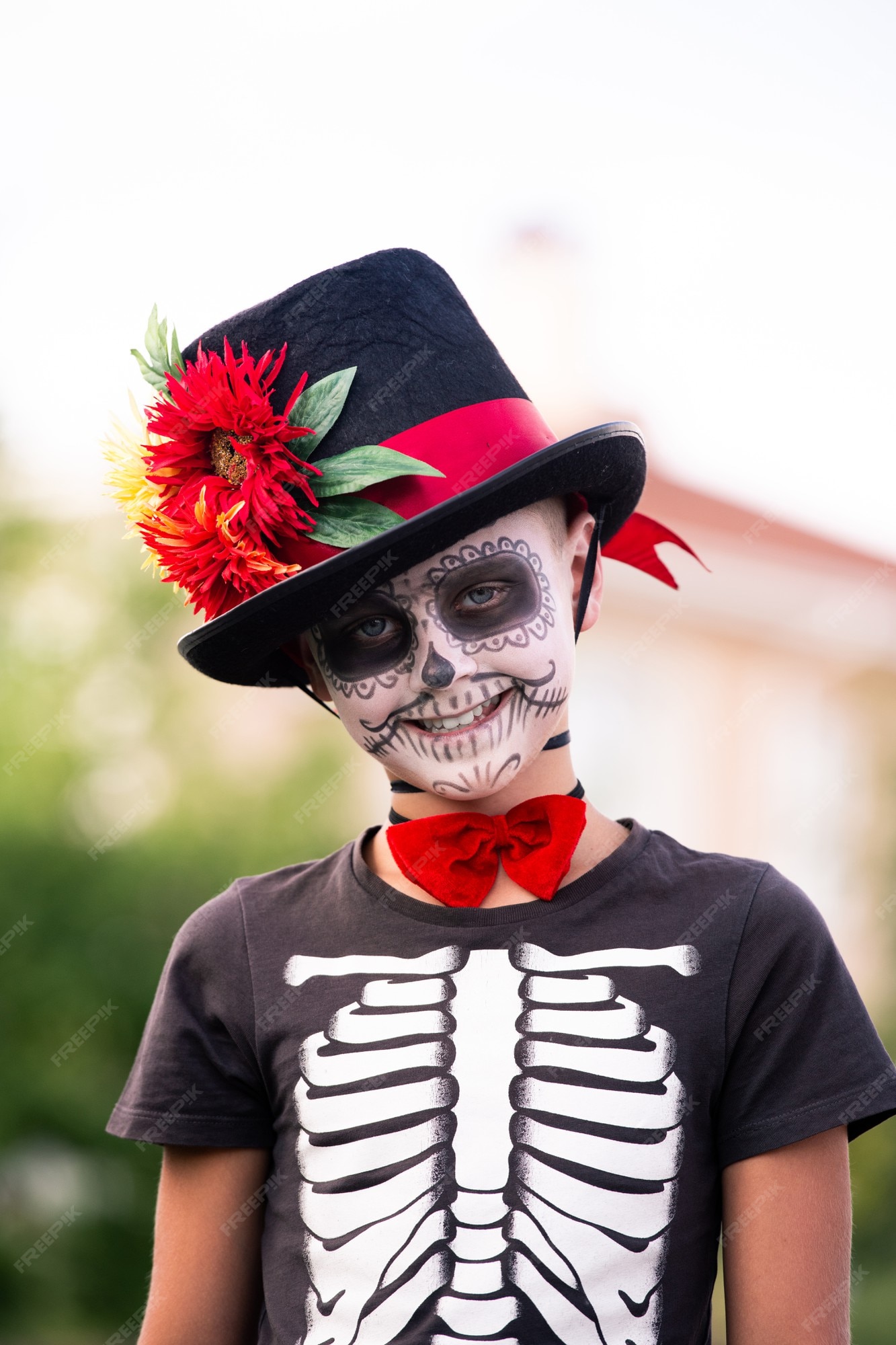 Lindo colegial con la cara pintada en disfraz de halloween de esqueleto con elegante sombrero negro de pie frente a la cámara y sonriéndole | Foto Premium Lindo colegial con la cara pintada en disfraz de halloween de esqueleto con elegante sombrero negro de pie frente a la cámara y sonriéndole | Foto Premium
