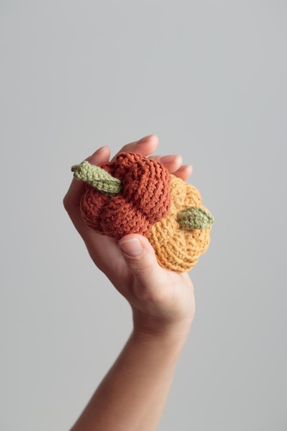 Lindo crochet tejido calabazas amarillas y naranjas sobre fondo blanco.