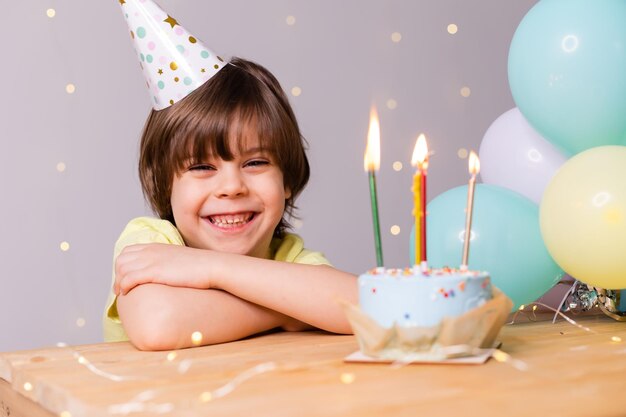 Lindo cumpleañero en pastel de sombrero con velas globos feliz cumpleaños