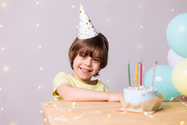 Lindo cumpleañero en pastel de sombrero con velas globos feliz cumpleaños