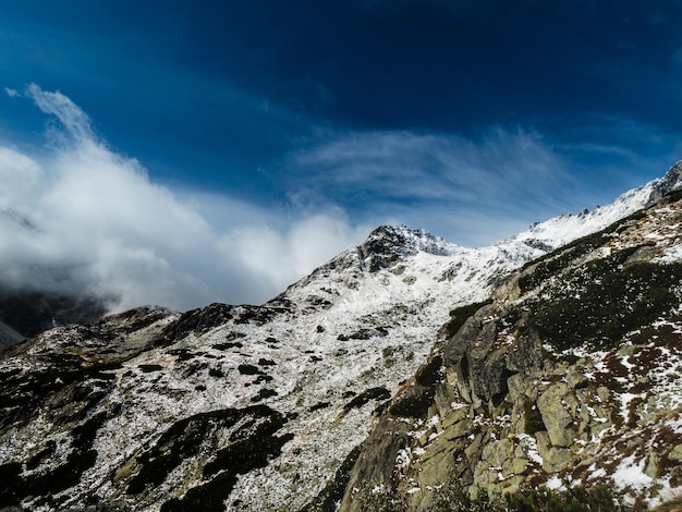 Foto lindo dia nublado nas montanhas com pico de montanha coberto de neve cume de neve no tatra eslovaco