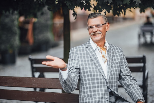 Lindo dia, velho elegante empresário sorrindo para a rua