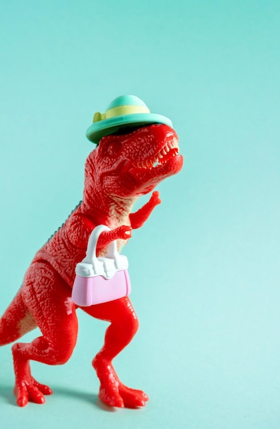 Lindo dinosaurio rojo con sombrero con monedero sobre fondo azul