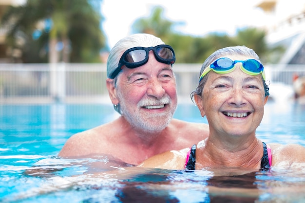 Lindo e fofo close de dois idosos na piscina se divertindo juntos - condicionamento físico e estilo de vida saudável - verão juntos