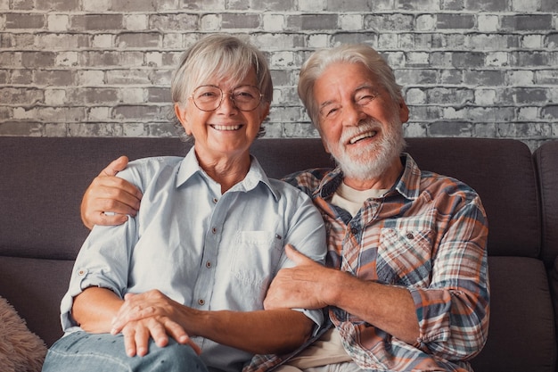 Lindo e lindo casal de idosos sorrindo e olhando para a câmera se divertindo em casa juntos Retrato de idosos sentados no sofá curtindo e relaxando