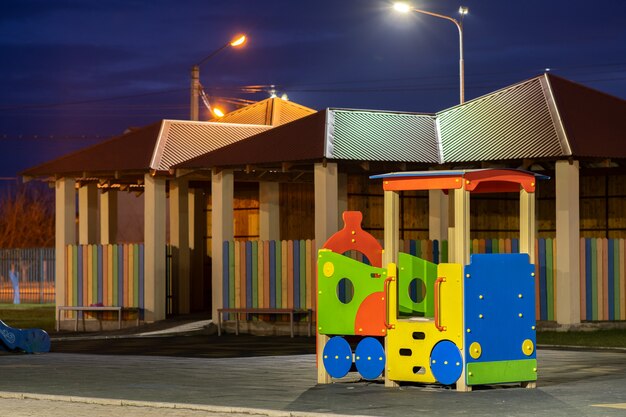 Lindo e moderno playground no jardim de infância com piso de borracha macia e novo carro de brinquedo grande e multicolorido brilhante