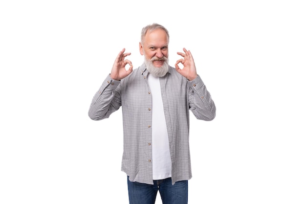 Lindo, encantador y inteligente abuelo con barba blanca y bigote está vestido con una camisa a rayas y