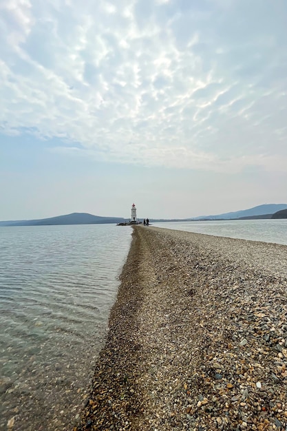 Foto lindo farol solitário com montanhas ao fundo