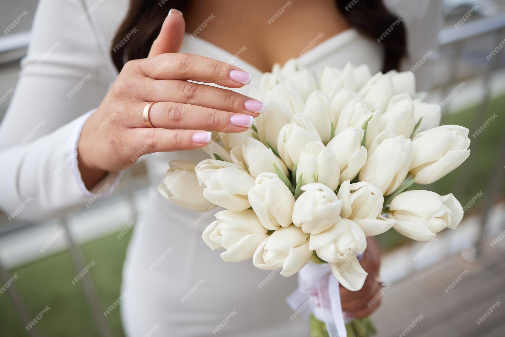 Lindo grande buquê de tulipas brancas nas mãos da noiva | Foto Premium