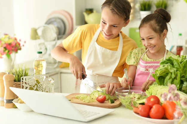 Lindo hermano y hermana cocinando juntos en la cocina