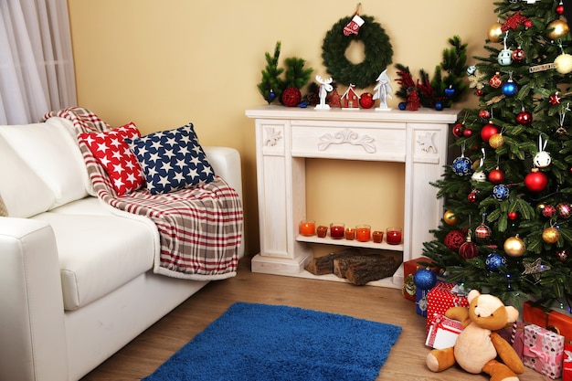 Lindo interior de Natal com sofá, lareira decorativa e pinheiro