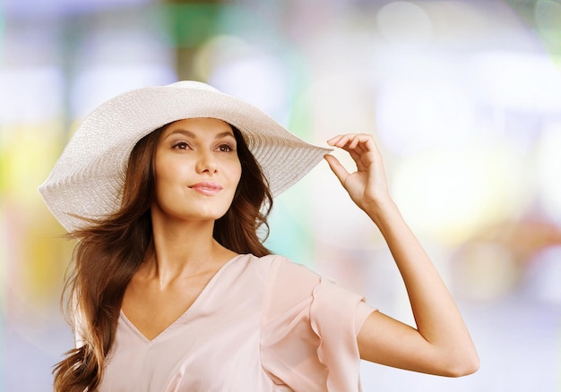 Lindo joven mujer con sombrero sobre fondo borroso