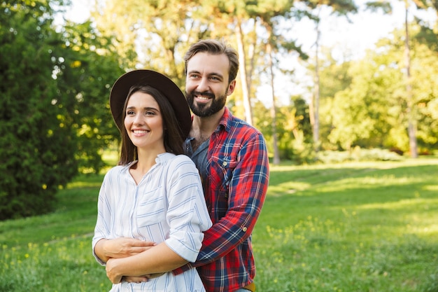 Lindo lindo casal apaixonado passando um tempo no parque, se abraçando