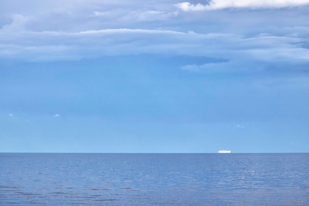 Lindo mar azul com um navio de cruzeiro ao fundo e céu e nuvens incrivelmente bonitos