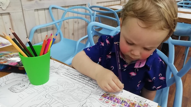 Lindo menino feliz adorável pré-escolar pintando em um estúdio de arte ensolarado Jovem artista no trabalho